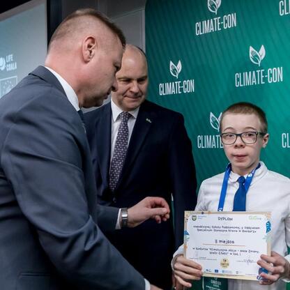 Rafał Adamczyk i Jan Bondaruk wręczają nagrody na Climate-Con 2025. (wygenerowano przez AI)