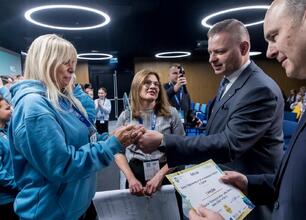 Podczas ceremonii zamknięcia konkursu "Klimatyczna Akcja – Małe Zmiany, Wielki Efekt!" w III Śląskim Konwencie Klimatycznym Climate-Con 2025, dziennikarz rozmawia z uczestniczką. (wygenerowano przez AI)