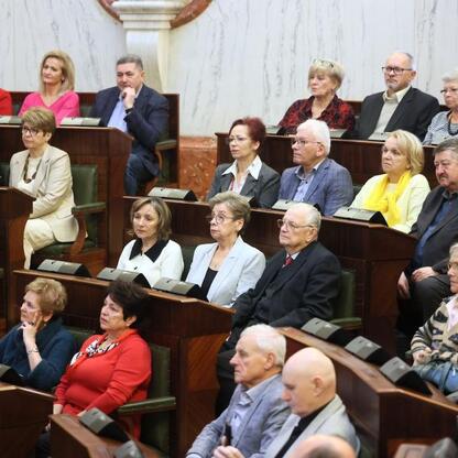W Sali Sejmu Śląskiego odbyła się pierwsza edycja Śląskiego Konwentu Rad Seniorów. Uczestnicy, w tym Rafał Adamczyk i Ewa Kołodziej, dyskutowali o roli rad seniorów i polityce samorządowej. (wygenerowano przez AI)