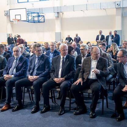 Grzegorz Boski, wicemarszałek województwa śląskiego, prowadzi spotkanie w gymnasium, omawiając przebudowę dróg DW 491 i DW 492 oraz reaktywację kolejowego połączenia. (wygenerowano przez AI)