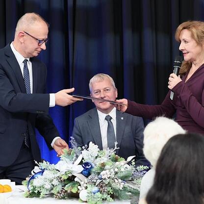 Wojciech Saługa, Marszałek Województwa Śląskiego, wręcza nagrodę na spotkaniu Śląskiej Rady Seniorów. (wygenerowano przez AI)