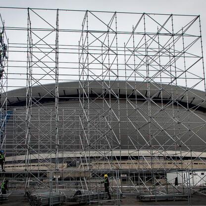 Stadion Śląski pod konstrukcją, z widocznymi pracownikami na szkieletach, w Katowicach, przygotowywany do imprezy sylwestrowej. (wygenerowano przez AI)