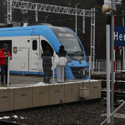 Nowy pociąg Impuls 2 Kolei Śląskich na stacji Herby Nowe. Pasażerowie wsiadają na pociąg. (wygenerowano przez AI)