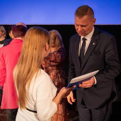 Rafał Adamczyk, członek Zarządu Województwa Śląskiego, wręcza dyplom laureatce wyróżnienia na Śląskim Orle Wolontariatu 2025. (wygenerowano przez AI)