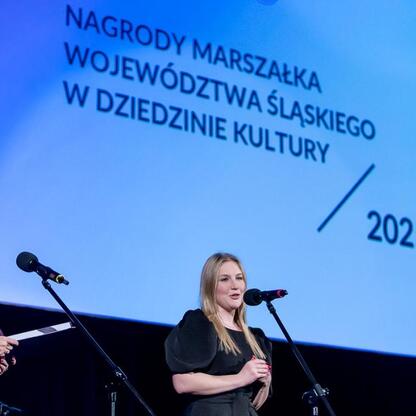 Joanna Bojczuk wręcza nagrodę na ceremonii Marszałka Województwa Śląskiego w Kinoteatrze Rialto w Katowicach. (wygenerowano przez AI)