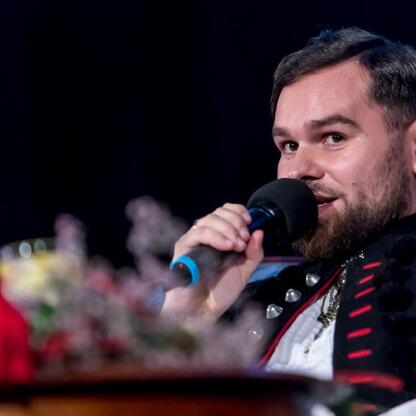 Mężczyzna przemawia na ceremonii wręczenia nagród Marszałkowskich w Sosnowcu, podczas uroczystości kulturalnych. (wygenerowano przez AI)