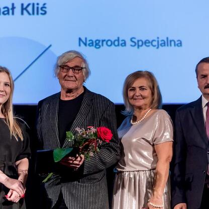 Na zdjęciu: Członkini Zarządu Województwa Śląskiego, Joanna Bojczuk, wręcza nagrodę Michałowi Kliśowi, laureatowi Nagrody Specjalnej Marszałka Województwa Śląskiego w dziedzinie sztuk plastycznych. (wygenerowano przez AI)