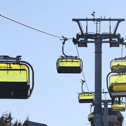 Zimowe atrakcje w Beskidach. Ski lift system na tle niebieskiego nieba. (wygenerowano przez AI)