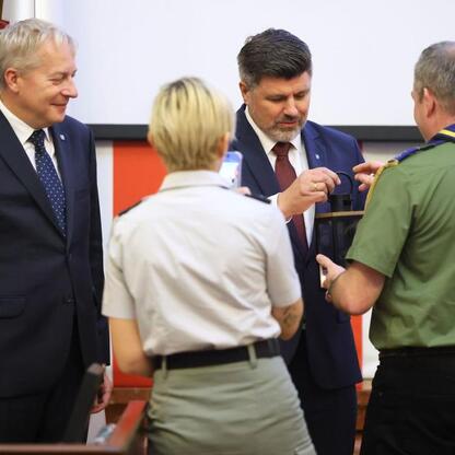Wojciech Saługa, Marszałek Województwa Śląskiego, wręcza odznaczenie scoutowi podczas sesji Sejmiku Województwa Śląskiego. (wygenerowano przez AI)