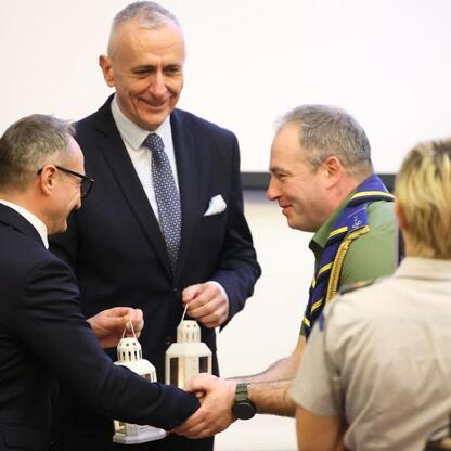 Wicemarszałek Województwa Śląskiego Leszek Pietraszek prezentuje lampionowi w mundurze, symbolizując gest dobrej woli. (wygenerowano przez AI)