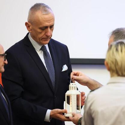 Wicemarszałek Leszek Pietraszek odbiera Betlejemski Światełko Pokoju od Grzegorza Boskiego, podczas prezentacji budżetu Województwa Śląskiego. (wygenerowano przez AI)