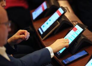W trakcie sesji Sejmiku Województwa Śląskiego, kobieta przemawia na podium z dekoracjami świątecznymi. (wygenerowano przez AI)