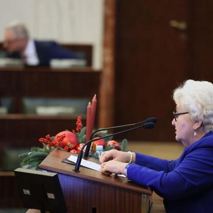 W trakcie sesji Sejmiku Województwa Śląskiego, kobieta przemawia na podium z dekoracjami świątecznymi. (wygenerowano przez AI)