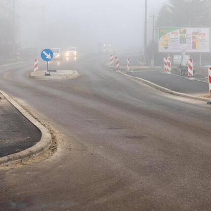Nowo wyremontowana droga wojewódzka 928 w Śląsku, gdzie prace zbliżają się do zakończenia. Pracownicy w ochronie wykonują finałowe prace na nowo wyłożonym asfaltowym odcinku. (wygenerowano przez AI)