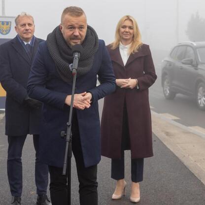 Oficjalna konferencja prasowa o zakończeniu pierwszej fazy rekonstrukcji drogi wojewódzkiej 928, z udziałem Wojciecha Saługi i innych władz. (wygenerowano przez AI)