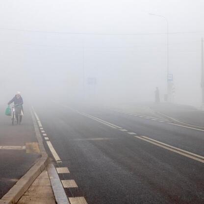 Foggy road intersection during Nowa DW 928 reconstruction, highlighting challenges posed by weather and safety measures. (wygenerowano przez AI)