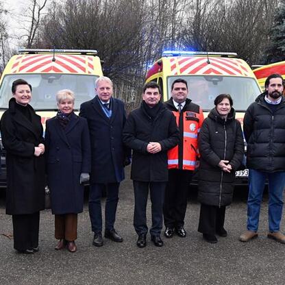Grupa oficjalnych osób podczas briefingu prasowego o nowych ambulansach dla Wojewódzkiego Pogotowia Ratunkowego w Katowicach. (wygenerowano przez AI)