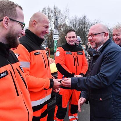 Wojciech Saługa, marszałek Województwa Śląskiego, omawia nowe ambulanse dla Wojewódzkiego Pogotowia Ratunkowego w Katowicach. (wygenerowano przez AI)