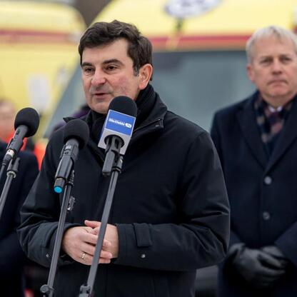 Marszałek Wojciech Saługa przemawia na konferencji prasowej, podczas przekazania nowych ambulansów w Sosnowcu. (wygenerowano przez AI)