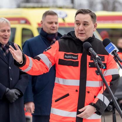 Marszałek Wojciech Saługa przemawia na ceremonii przekazania nowych ambulansów w Sosnowcu. (wygenerowano przez AI)