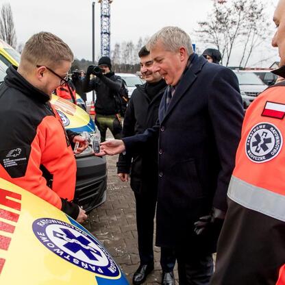 Marszałek Wojciech Saługa i członkowie zarządu regionu uczestniczą w ceremonii przekazania nowych ambulansów i sprzętu medycznego dla Regionalnego Pogotowia Ratunkowego w Sosnowcu. (wygenerowano przez AI)