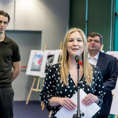 Joanna Bojczuk, Członkini Zarządu Województwa Śląskiego, przemawia na konferencji prasowej w Superauto.pl Stadionu Śląskiego. (wygenerowano przez AI)