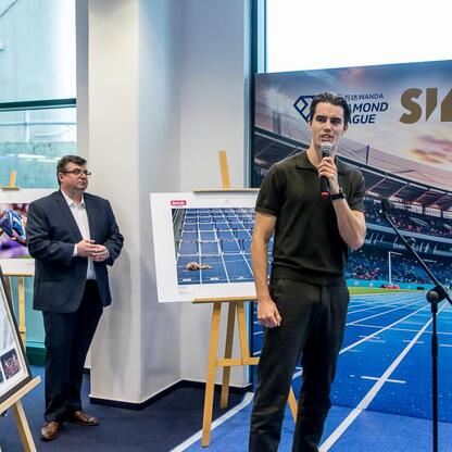 Członkini Zarządu Województwa Śląskiego Joanna Bojczuk przemawia na konferencji prasowej w Superauto.pl Stadionu Śląskiego, podczas której zaprezentowano nowy eksponat – koszulkę mistrza olimpijskiego (wygenerowano przez AI)