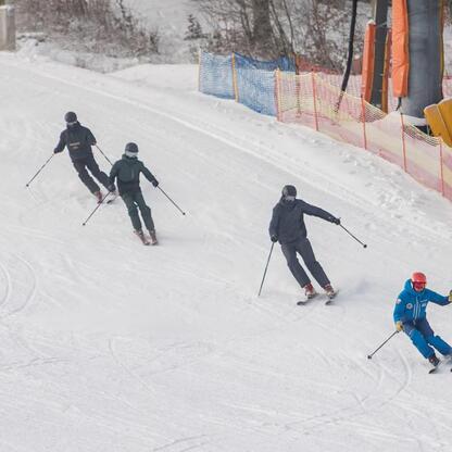 Skierzy na śnieżnym stoku, ubrani w zimowe stroje, z nartami i kijkami, cieszą się zimowym sportem. (wygenerowano przez AI)
