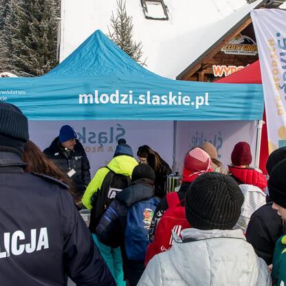 Grupa dzieci przed namiotem z policjantem, zaznaczająca bezpieczeństwo w zimowym środowisku. (wygenerowano przez AI)