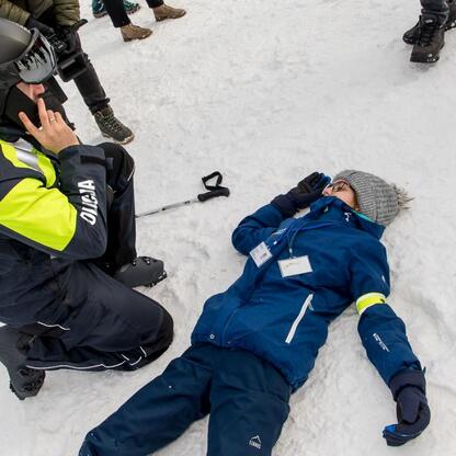 Policjant pomaga osobie na śniegu, akcja 