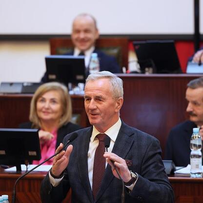Formalna sesja Sejmiku Województwa Śląskiego w 2026 roku, gdzie radni dyskutują o rozwinięciu infrastruktury sportowej i transportowej. (wygenerowano przez AI)