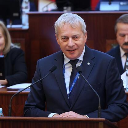 Marszałek Województwa Śląskiego Wojciech Saługa przemawia podczas sesji parlamentarnej, podkreślając znaczenie języka śląskiego i inwestycje w infrastrukturę. (wygenerowano przez AI)