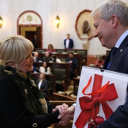 Formalne spotkanie w gmachu parlamentarnym, Marszałek Saługa i Marcin Ryś podają sobie ręce, podczas gdy Joanna Pasierbek-Konieczny obserwuje. (wygenerowano przez AI)