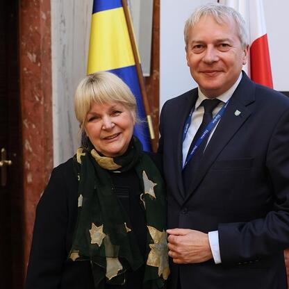 Marszałek Województwa Śląskiego Wojciech Saługa i nieznana osoba w formalnej odzieży przed flagami, prawdopodobnie na konferencji lub sesji. (wygenerowano przez AI)
