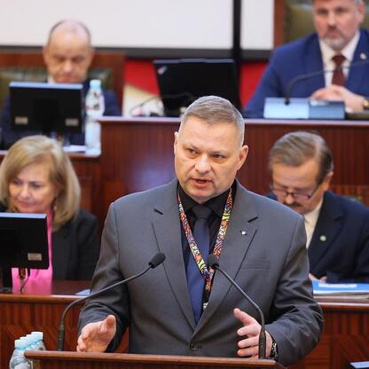 Rafał Adamczyk, członek zarządu województwa, przemawia na sesji Sejmiku Województwa Śląskiego, omawiając rozwój infrastruktury i regionalne projekty. (wygenerowano przez AI)