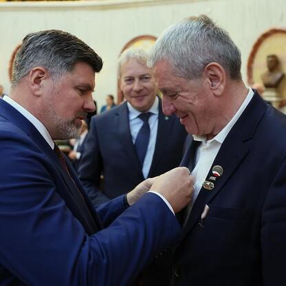 Wojciech Saługa i Rafał Adamczyk uczestniczą w ceremonii wręczenia medali, podkreślając znaczenie regionalnych inicjatyw. (wygenerowano przez AI)