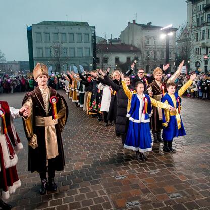 Inauguracja Bielska-Białej jako Polskiej Stolicy Kultury 2026. Uczestnicy w tradycyjnych strojach uczestniczą w paradzie, tło: tłum i dekoracje świąteczne. (wygenerowano przez AI)