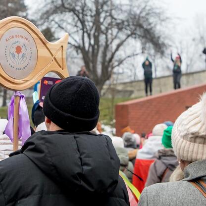 Zbiór osób w zimowych ubraniach zgromadzonych na ceglanym pomniku, uczestniczący w inauguracji Bielska-Białej jako pierwszej Polskiej Stolicy Kultury. (wygenerowano przez AI)