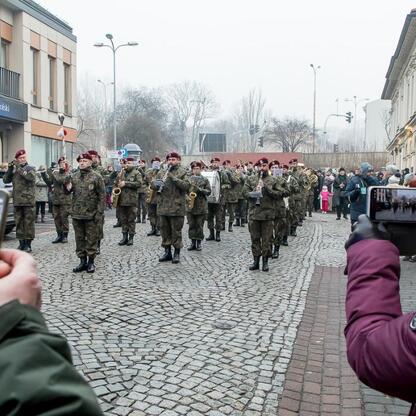 Inauguracja Bielska-Białej jako Polskiej Stolicy Kultury 2026. Militarna orkiestra gra na ulicach miasta, publiczność obserwuje. (wygenerowano przez AI)