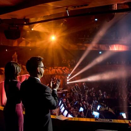 Inauguracyjny koncert w Bielsku-Białej, oświetlony złotym światłem, z publicznością pełną entuzjazmu. (wygenerowano przez AI)