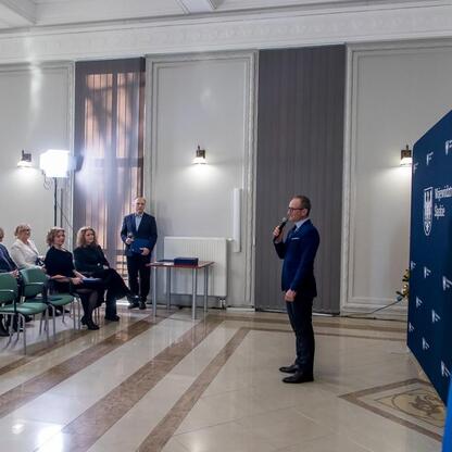 Grzegorz Boski, wicemarszałek Śląska, wręcza symboliczne listy gratulacyjne beneficjentom projektów wodno-ściekowych. (wygenerowano przez AI)