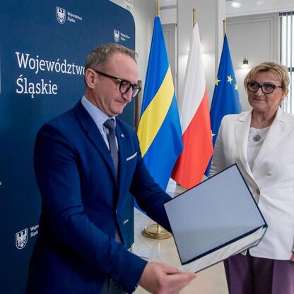 Wicemarszałek Grzegorz Boski wręcza dokumenty w ramach funduszy dla zarządzania wodami i ściekami w województwie śląskim. (wygenerowano przez AI)