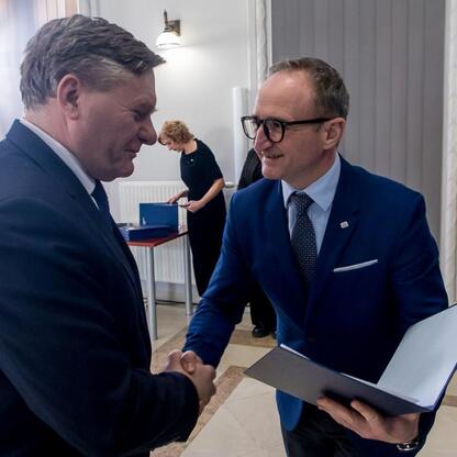 Grzegorz Boski, wicemarszałek Województwa Śląskiego, wręcza symboliczne listy gratulacyjne beneficjentom projektów wodno-ściekowych. (wygenerowano przez AI)