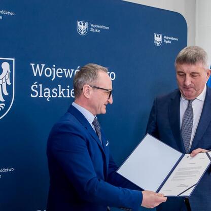 Grzegorz Boski, Wicemarszałek Województwa Śląskiego, wręcza symboliczne listy gratulacyjne beneficjentom projektów wodno-ściekowych. (wygenerowano przez AI)