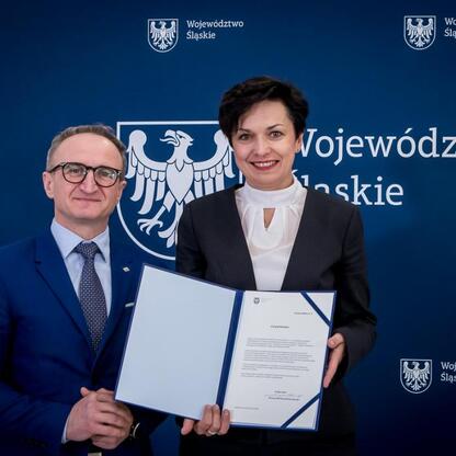 Grzegorz Boski, wicemarszałek Województwa Śląskiego, wręcza beneficjentom listy gratulacyjne. (wygenerowano przez AI)