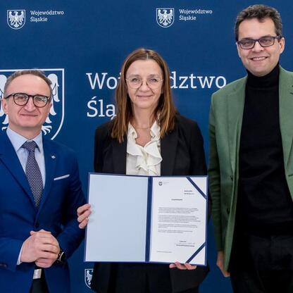 Grzegorz Boski, wicemarszałek Województwa Śląskiego, wręcza beneficjentom listy gratulacyjne za wsparcie w projektach wodno-ściekowych. (wygenerowano przez AI)