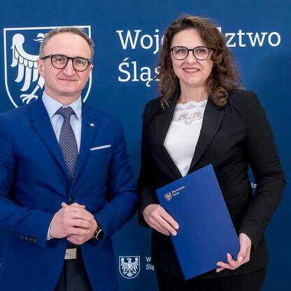 Grzegorz Boski, wicemarszałek Województwa Śląskiego, wręcza gratulacje w ramach symbolicznego uroczystego momentu. (wygenerowano przez AI)