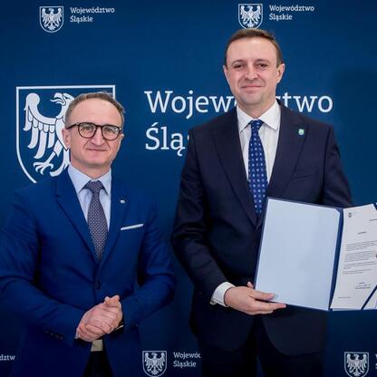 Grzegorz Boski, wicemarszałek Województwa Śląskiego, wręcza beneficjentom listy gratulacyjne. (wygenerowano przez AI)