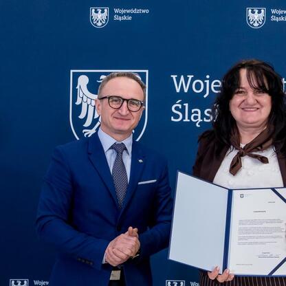 Grzegorz Boski, wicemarszałek Śląska, wręcza listy gratulacyjne beneficjentom programu wsparcia wodno-ściekowego. (wygenerowano przez AI)
