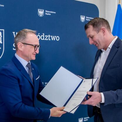 Grzegorz Boski, wicemarszałek Śląska, wręcza dokumenty przedstawicielowi projektu województwa. (wygenerowano przez AI)
